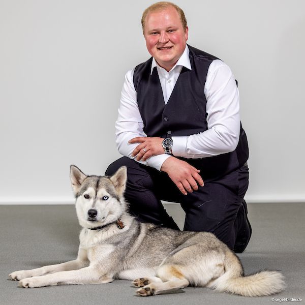 Inhaber Kay Seemann von der Haustierbestattung LiebesTier Bestattung hockt neben seiner Husky Hundedame Holly